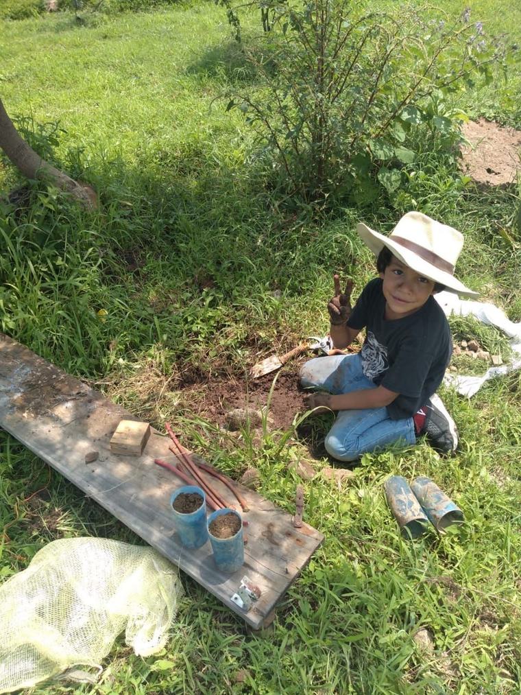 Niño sembrando en el huerto de Pakkitlán, con las manos en la tierra